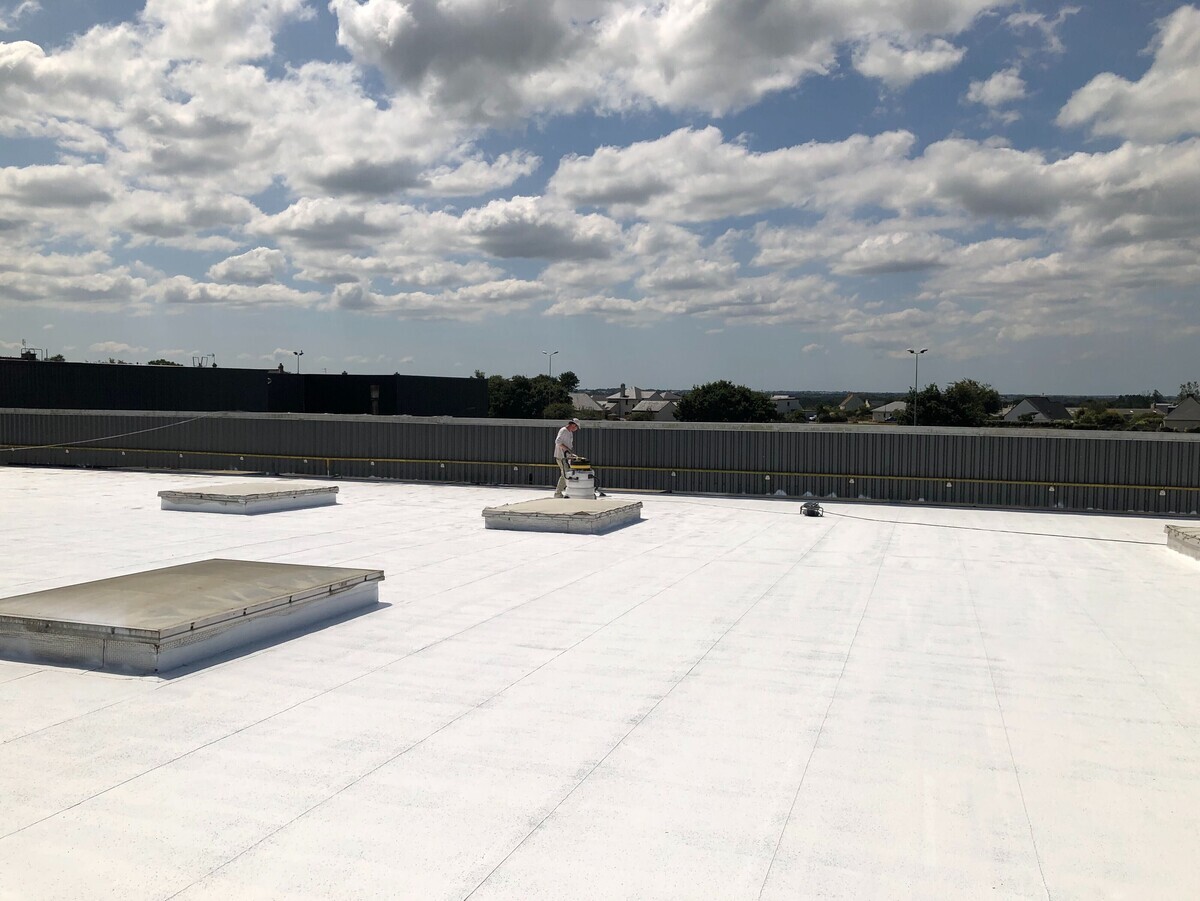 Chantier BRH à Lorient : grande toiture industrielle traitée en cool roof, en cours d'application.